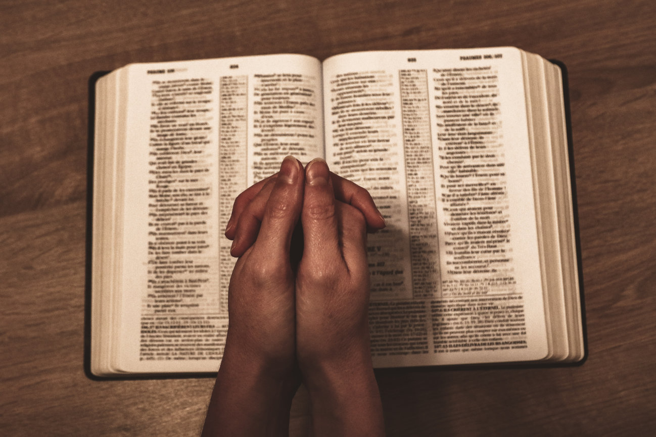 praying hands with Bible