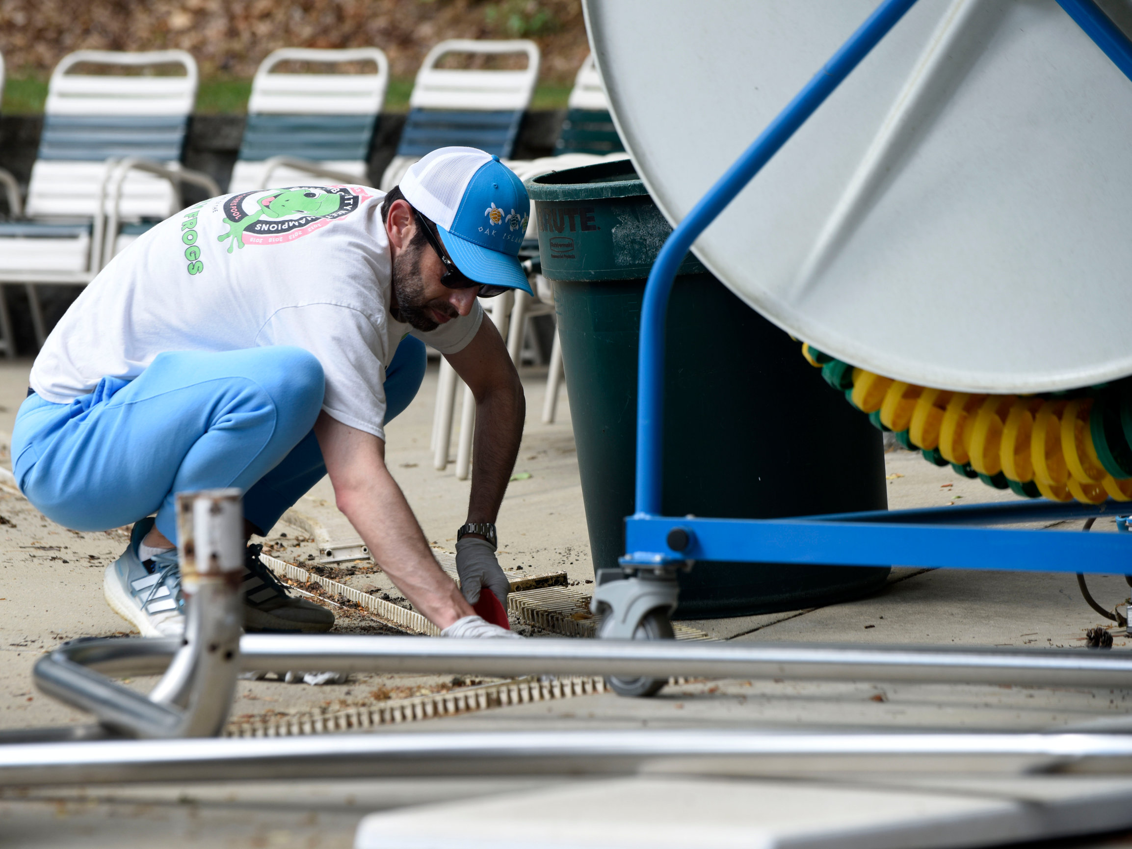 A photo of Friendly Park members Jason Gould helping to clean pool gutter drains in 2025.